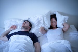 Tired and annoyed woman of her boyfriend snoring in bed